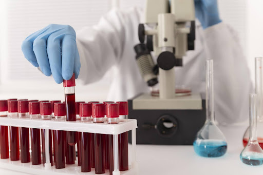 Front view of a scientist testing blood samples through a microscope
